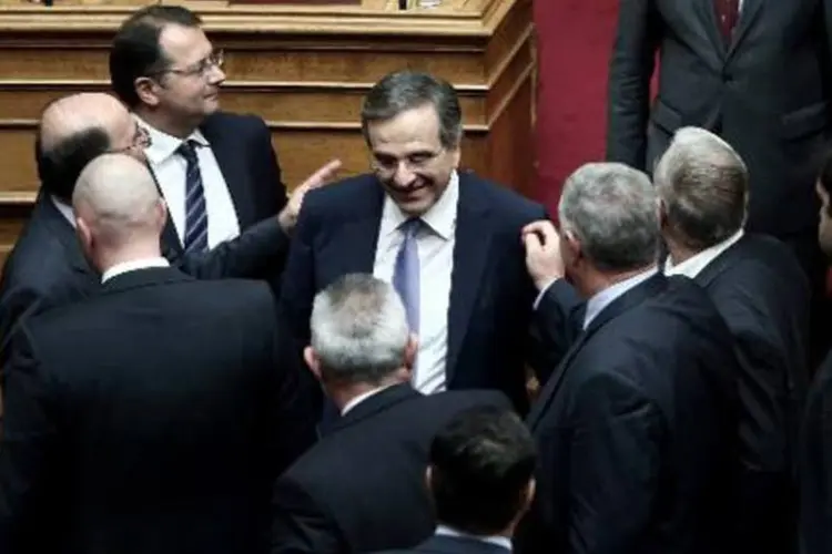 O primeiro-ministro grego Antonis Samaras (C) recebe os cumprimentos dos deputados após a aprovação do orçamento (Angelos Tzortzinis/AFP)