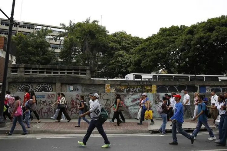 Venezuelanos caminham depois que os serviços do metrô foram interrompidos por um apagão em Caracas (Carlos Garcia Rawlins/Reuters)
