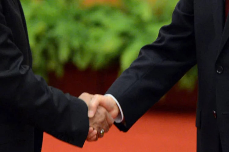 Aperto de mão entre dois homens de terno (Getty Images/Pool)