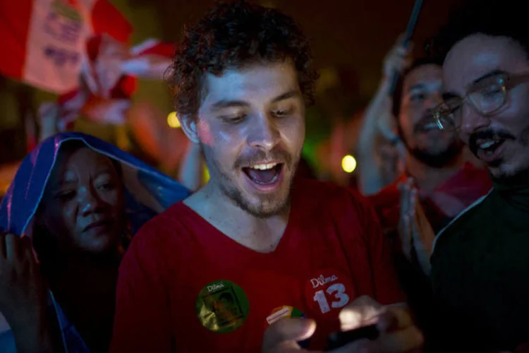 
	Eleitores comemoram a reelei&ccedil;&atilde;o de Dilma: vit&oacute;ria pode indicar mais preju&iacute;zos para os investidores
 (Dado Galdieri/Bloomberg)