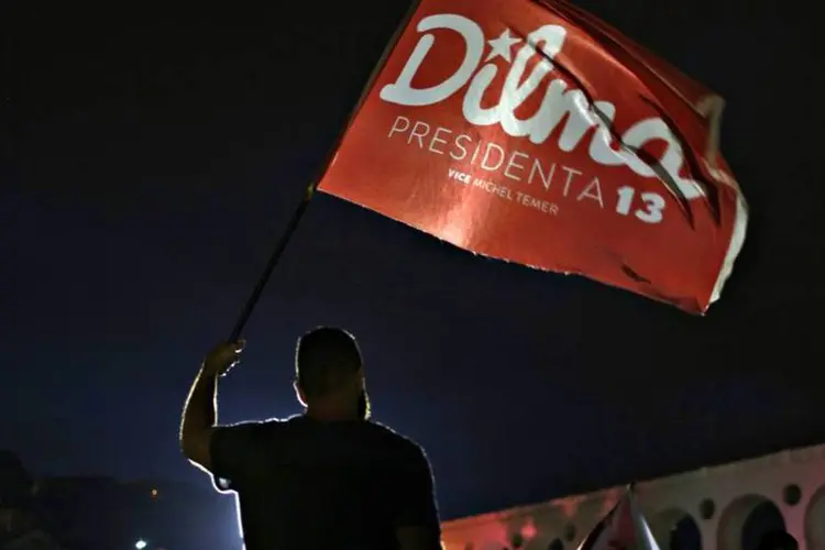 
	Um apoiador do PT segura bandeira com o nome de Dilma Rousseff (PT) no Rio de Janeiro
 (REUTERS/Pilar Olivares)