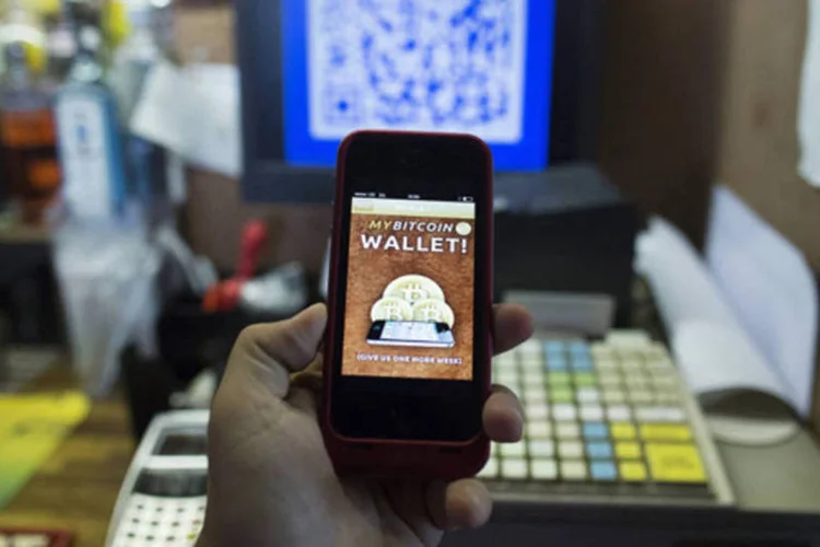 
	Aplicativo do Bitcoin: moeda surgiu em 2009 de um c&oacute;digo-fonte escrito por um desenvolvedor ou um grupo de desenvolvedores an&ocirc;nimo que usa o nome de Satoshi Nakamoto
 (Simon Dawson/Bloomberg)