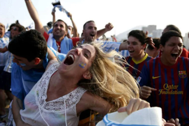 
	Torcedores da Argentina comemoram na praia de Copacabana, no Rio de Janeiro
 (REUTERS/Pilar Olivares)