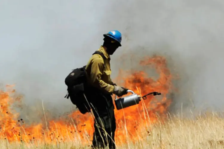 Bombeiro joga líquido para conter o fogo que se espalha pelo estado (Kevork Djansezian/Getty Images)