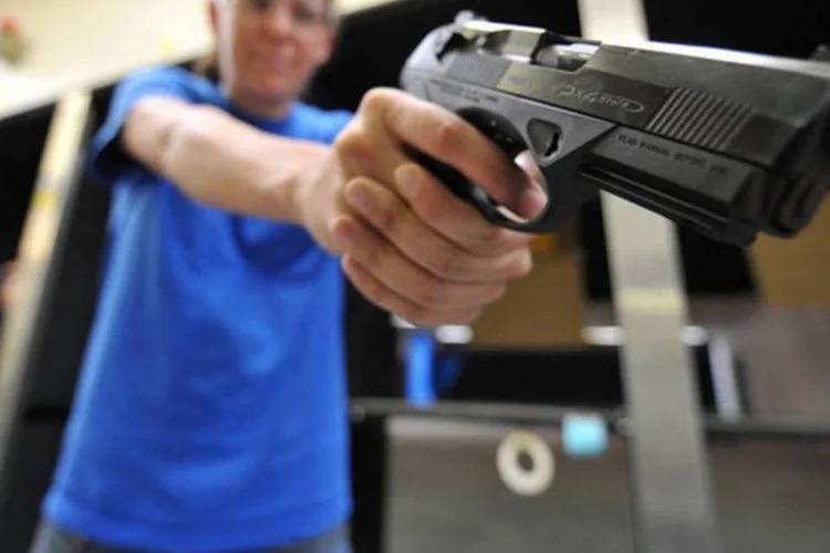 
	Funcion&aacute;rio de loja de armas exibe pistola: editores disseram que buscaram os portadores depois das mortes por tiros em uma escola de Newtown
 (Jewel Samad/AFP)