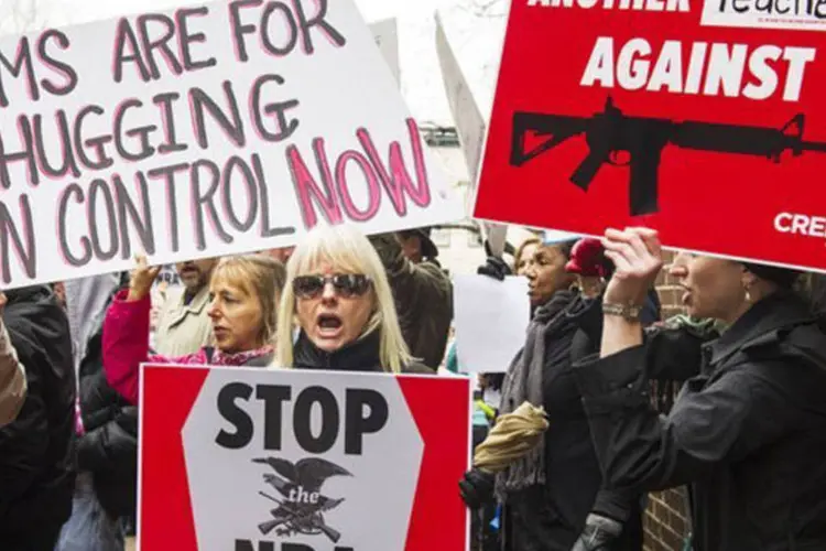 
	Manifestantes exigem o controle de armas diante da sede da Associa&ccedil;&atilde;o Nacional do Rifle em Washington
 (Paul J. Richards/AFP)