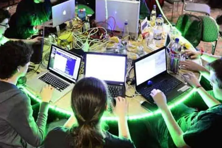 jovens em mesa com computadores (Getty Images)