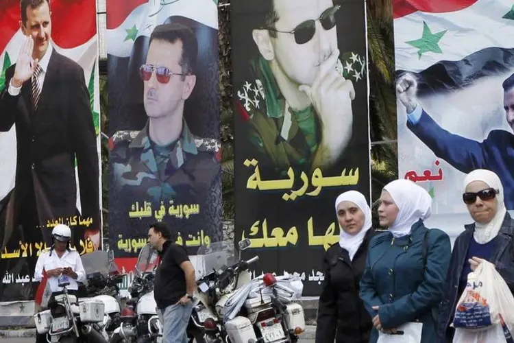 Cartazes do presidente Bashar al-Assad em uma rua de Damasco, na Síria (Khaled al-Hariri/Reuters)
