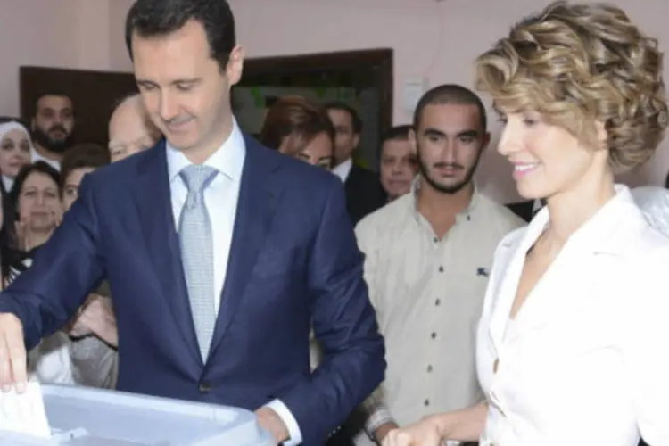 
	Presidente da S&iacute;ria, Bashar al-Assad, e sua esposa Asmaa, durante vota&ccedil;&atilde;o
 (Sana/Handout via Reuters)