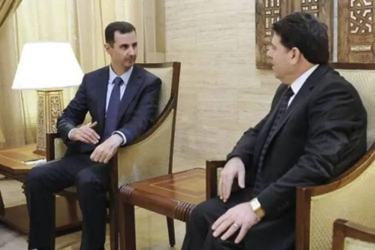 Presidente sírio, Bashar al-Assad, encontra-se com primeiro-ministro sírio, Wael al-Halki, após empossá-lo para o cargo, em Damasco (Sana/Divulgação/Reuters)