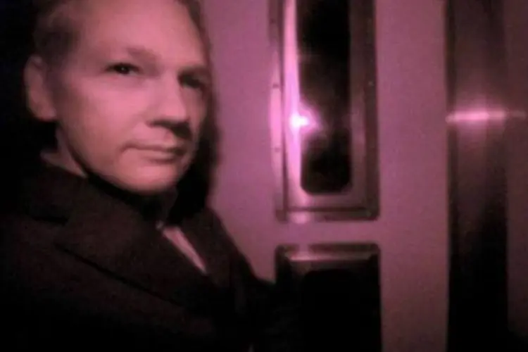 Julian Assange dentro de veículo da polícia ao chegar em tribunal de Londres (Carl Court/AFP)