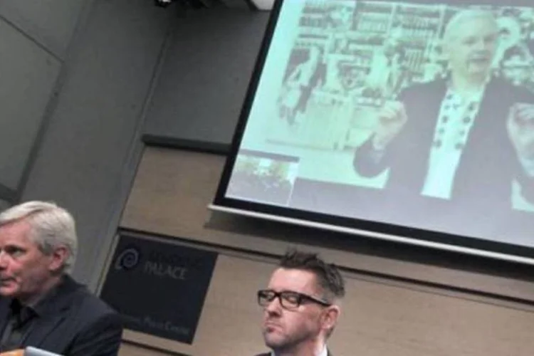 Assange aparece no telão, durante uma videoconferência em Bruxelas: Visa e MasterCard, há dois anos, negam-se a transferir doações a seu site (AFP / Georges Gobet)