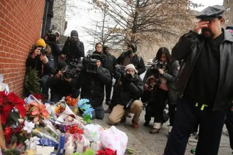 Homem observa flores e velas depositadas no local onde dois policiais foram assassinados no Brooklyn, em Nova York (Spencer Platt/AFP)