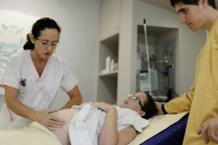 
	Assistente prepara mulher antes do parto em hospital
 (Jean-Sebastien Evrard/AFP)