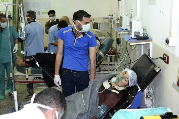 Mulher, afetada pelo que os ativistas dizem ser um ataque a gás na cidade de Telminnes, respira através de uma máscara de gás no hospital Bab al-Hawa, perto da fronteira com a Turquia (Amer Alfaj/Reuters)