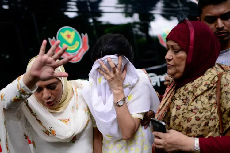 
	Pessoas reagem ao ataque em Bangladesh: quatro horas depois do in&iacute;cio da tomada de ref&eacute;ns, o grupo Estado Isl&acirc;mico (EI) reivindicou o ataque
 (Mahmud Hossain Opu/Handout via REUTERS)