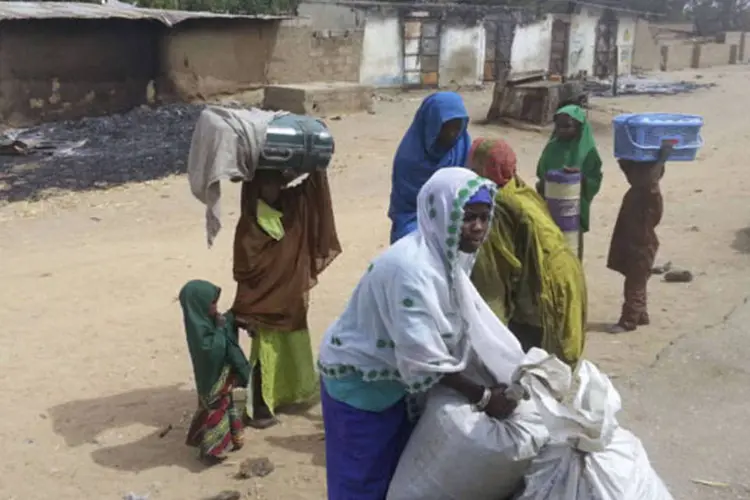 Mulher empacota o que sobrou de seus pertences após um ataque atribuído à Boko Haram, ocorrido no final de janeiro em Kawuri, na Nigéria (Reuters)