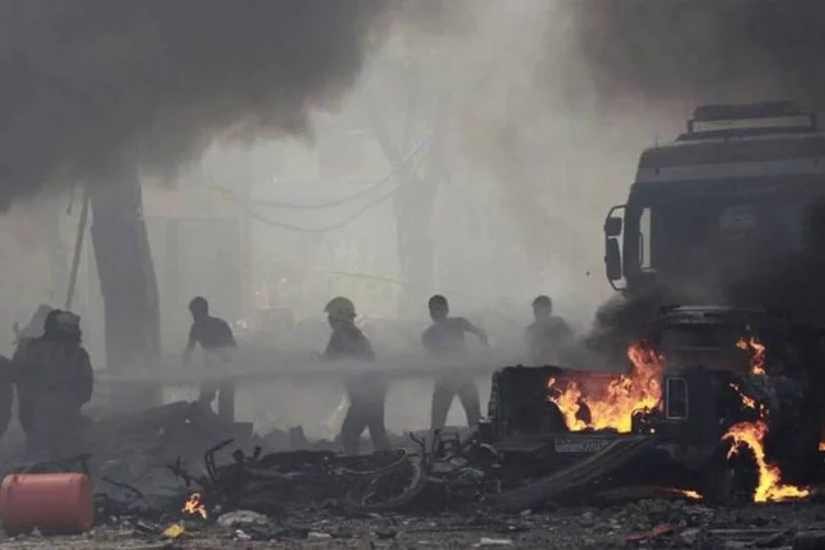 Residentes apagam incêndio provocado por ataque aéreo de forças leais ao presidente sírio, Bashar al Assad (Reuters)