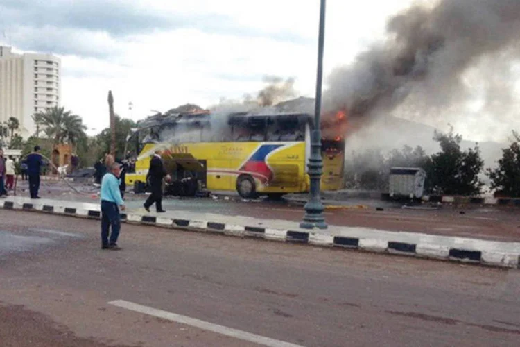 População e policiais olham a fumaça saindo de um ônibus de turistas na cidade de Taba, ao sul do Sinai, no Egito. Ataque ocorreu no dia 16 de fevereiro, e foi assumido pelo grupo Ansar Bayt al-Maqdis (Reuters)