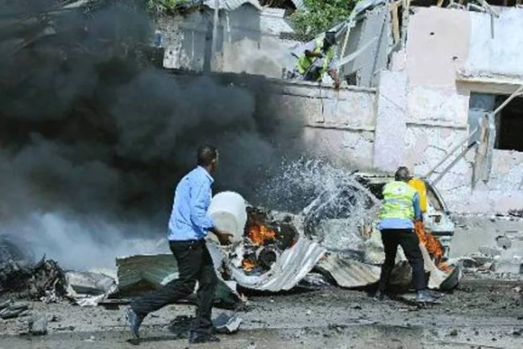 Forças de segurança da Somália correm para o local da explosão, perto dos portões do aeroporto de Mogadíscio (Mohamed Abdiwahab/AFP)