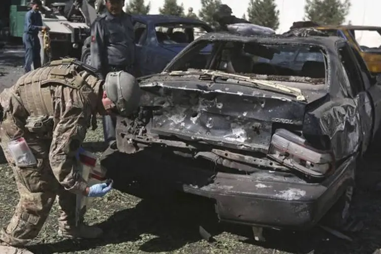 Afeganistão: soldado dos EUA investiga carro destruído em local de ataque suicida em Cabul (Omar Sobhani/Reuters)