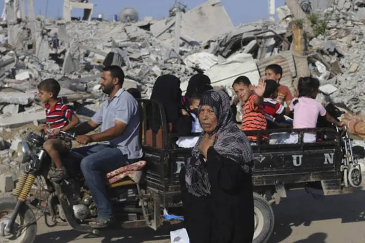Palestinos fogem após ataques aéreos de Israel em Khan Younis, ao sul da Faixa de Gaza (Ibraheem Abu Mustafa/Reuters)