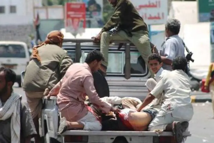 Pessoas feridas transportadas em caminhonete no dia 26 de março na cidade de Aden, sul do Iêmen (Saleh al Obeidi/AFP)