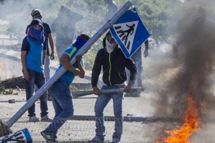 Árabes israelenses mascarados protestam em Kfar Kana contra a morte de um compatriota nas mãos da polícia de Israel (Jack Guez/AFP)