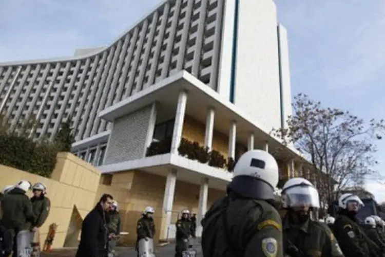 Policiais gregos vigiam hotel em Atenas, em uma nova sessão de protestos contra a crise
 (Angelos Tzortzinis/AFP)