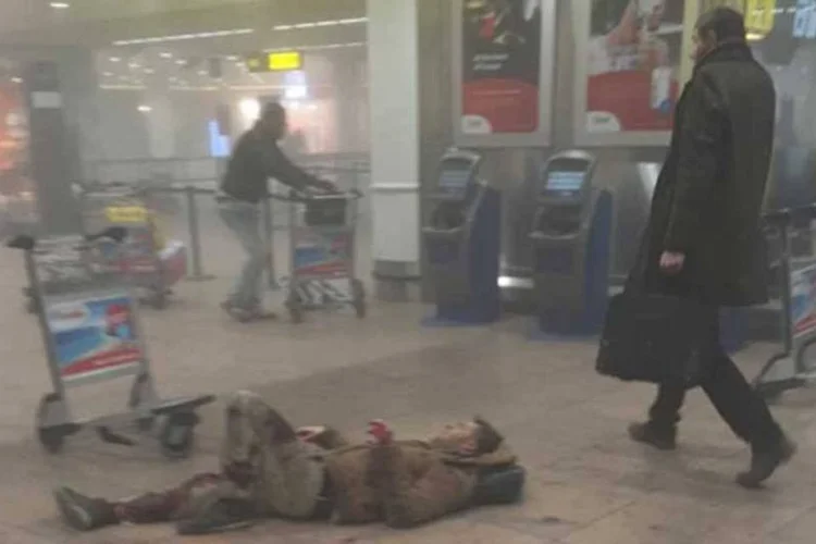 
	Homem atravessa sagu&atilde;o ao lado de um ferido no aeroporto de Bruxelas
 (Reprodução/ Facebook/ Ketevan Kardava)
