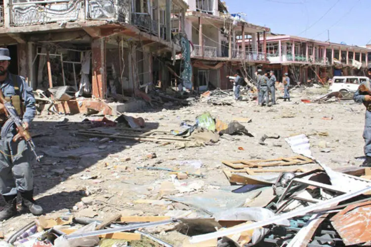 Ghazni, Afeganistão: polícia faz guarda em frente aos prédios danificados pelo atentado (Mustafa Andaleb/Reuters)