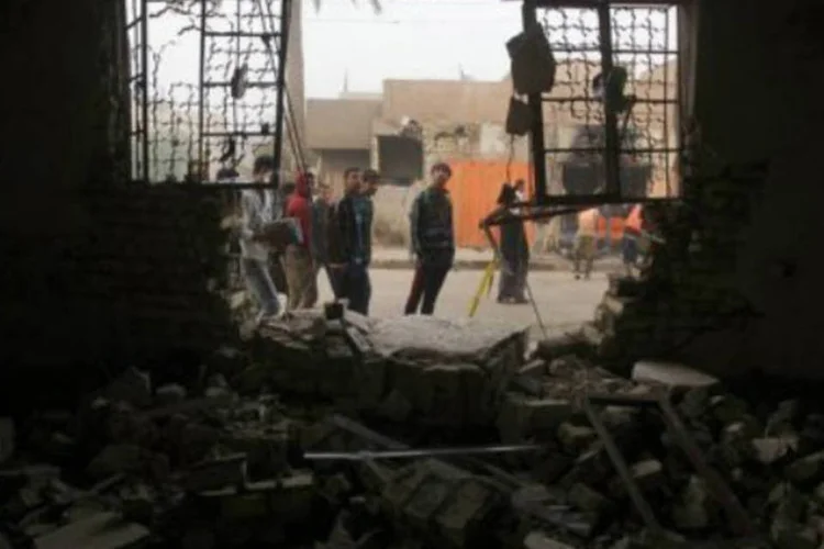 Iraquianos observam prédio atacado por carro-bomba no bairro xiita de Hurriyah, em Bagdá, em 28 de novembro (©AFP/Arquivo / Ahmad al-Rubaye)