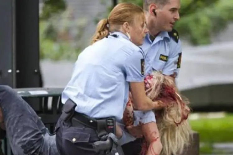 Policiais carregam ferido em explosão em Oslo:  a polícia não descartou que o número de mortos possa aumentar, já que ainda há "feridos em estado grave" que estão internados (AFP)