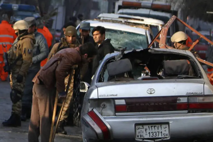 Trabalhador do restaurante que foi atacado por home-bomba observa veículo danificado em Cabul, no dia 18 de janeiro de 2014 (REUTERS/Mohammad Ismail)