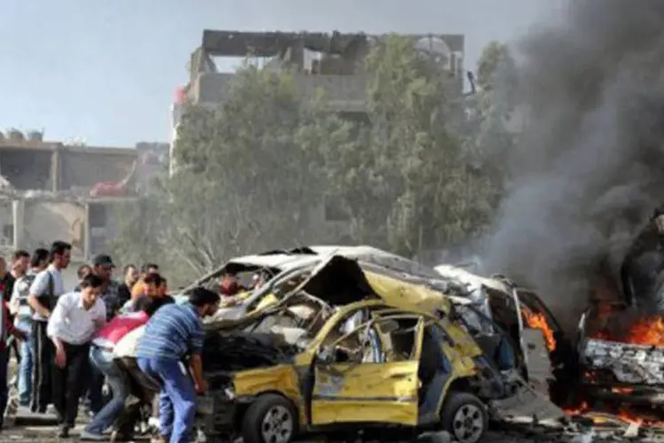 Os serviços de emergência retiravam os cadáveres carbonizados dos restos dos veículos
 (AFP)