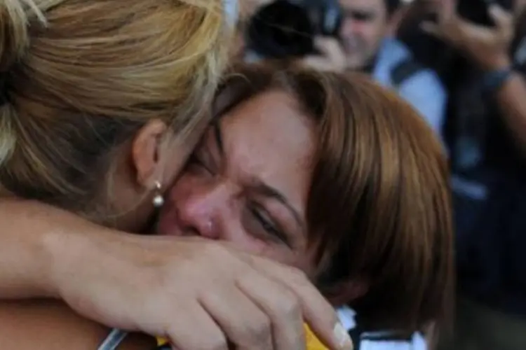Mãe consola filha sobrevivente a ataque de atirador no realengo (AFP  Vasileios Filis)