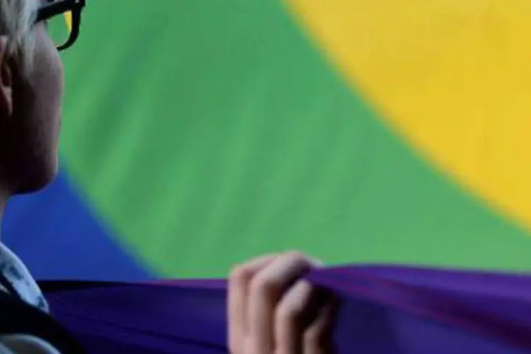 Ativista exibe uma bandeira com as cores do arco-íris: Vladimir Luxuria foi presa pela polícia russa e expulsa do parque olímpico (Filippo Monteforte/AFP)