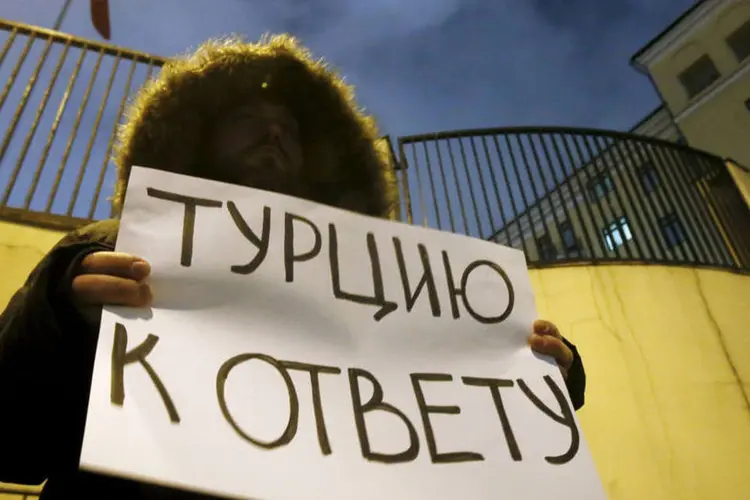 
	Ativista na frente da embaixada da Turquia em Moscou segura cartaz que pede a Turquia que &quot;preste contas&quot; sobre avi&atilde;o abatido
 (Maxim Shemetov / Reuters)