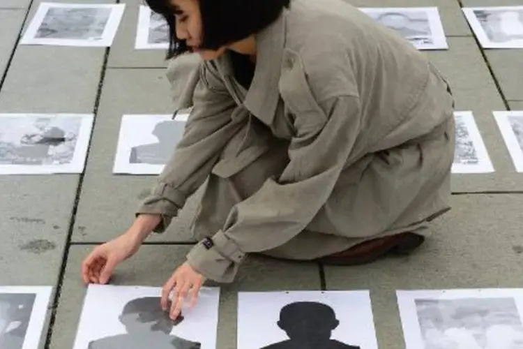 Ativista mostra fotos de tibetanos que se autoimolaram: mais de 125 tibetanos cometeram atos de imolação desde 2009 (John Macdougall/AFP)