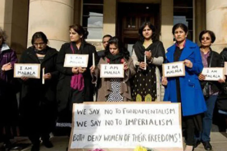 
	Ativistas fazem vig&iacute;lia em Birmingham: os participantes seguraram cartazes com a frase &quot;Eu sou Malala&quot; e colocaram dois buqu&ecirc;s de flores brancas e rosas no ch&atilde;o
 (Gavin Fogg/AFP)