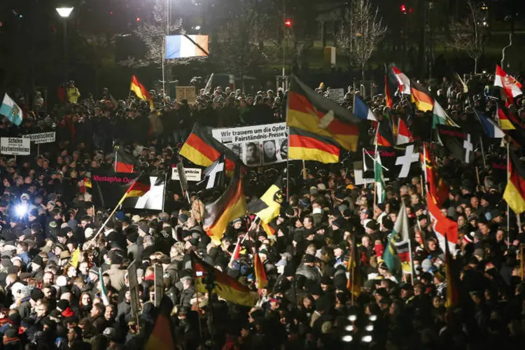 
	Apoiadores do movimento anti-imigra&ccedil;&atilde;o Pegida seguram bandeiras durante protesto na Alemanha
 (Fabrizio Bensch/Reuters)