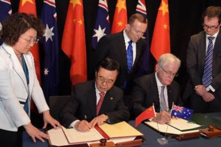 
	O ministro australiano do Comercio, Andrew Robb, e seu colega chin&ecirc;s, Gao Huchen assinam o acordo: em 2014, a China se converteu no primeiro investidor estrangeiro na Austr&aacute;lia, ficando &agrave; frente dos EUA
 (AFP/ LUKAS COCH)