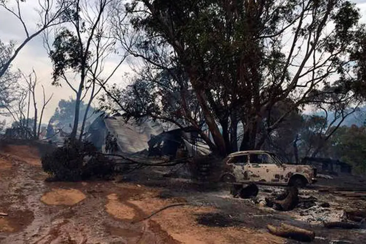 Destroços de um carro e de uma casa são vistos após incêndio na Austrália (REUTERS/Tom Fedorowytsch-ABC NEWS)