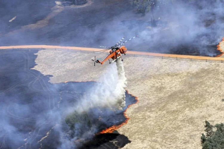 
	Helic&oacute;ptero despeja &aacute;gua em inc&ecirc;ndio nos Montes Granpians: Temperaturas chegaram a 45&ordm; na regi&atilde;o
 (Country Fire Authority (CFA)/ Distribuído via Reuters)