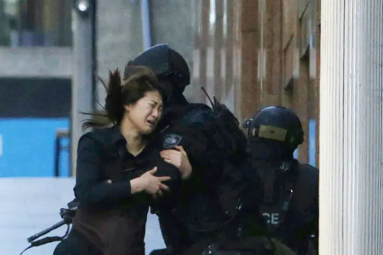 
	Imagem mostra o momento em que uma das ref&eacute;ns conseguiu escapar do caf&eacute; em Sydney
 (Reuters)