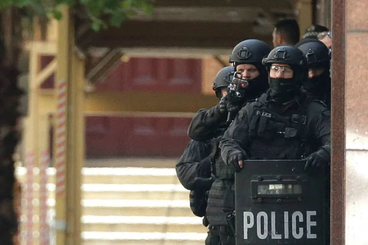 Policiais fazem cerco ao café no qual está em andamento o sequestro de um número não divulgado de pessoas (Reuters)