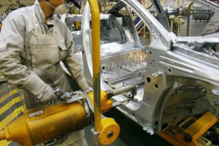 Operário chinês trabalha em fábrica de automóveis: se o resultado de 7,7% for confirmado, a China terá o pior crescimento em 13 anos
 (AFP)