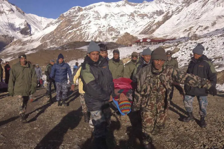 
	Soldados nepalenses resgatam uma v&iacute;tima de uma avalanche
 (Exército do Nepal/Divulgação via Reuters)