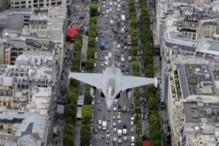 Avião francês Rafale sobrevoa o Avenida Champs Elysee, em Paris, França (Anne-Christine Poujoulat/AFP)