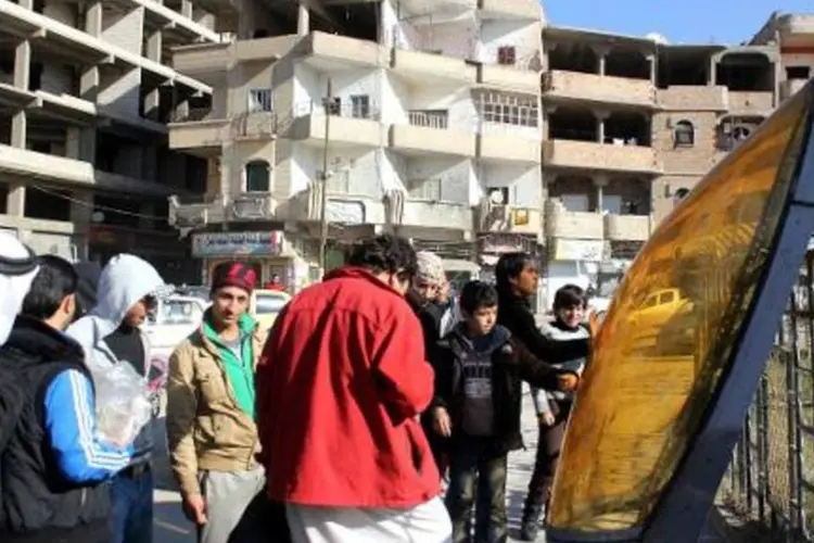 Sírios observam destroços de avião jordaniano na região de Raqa (AFP)